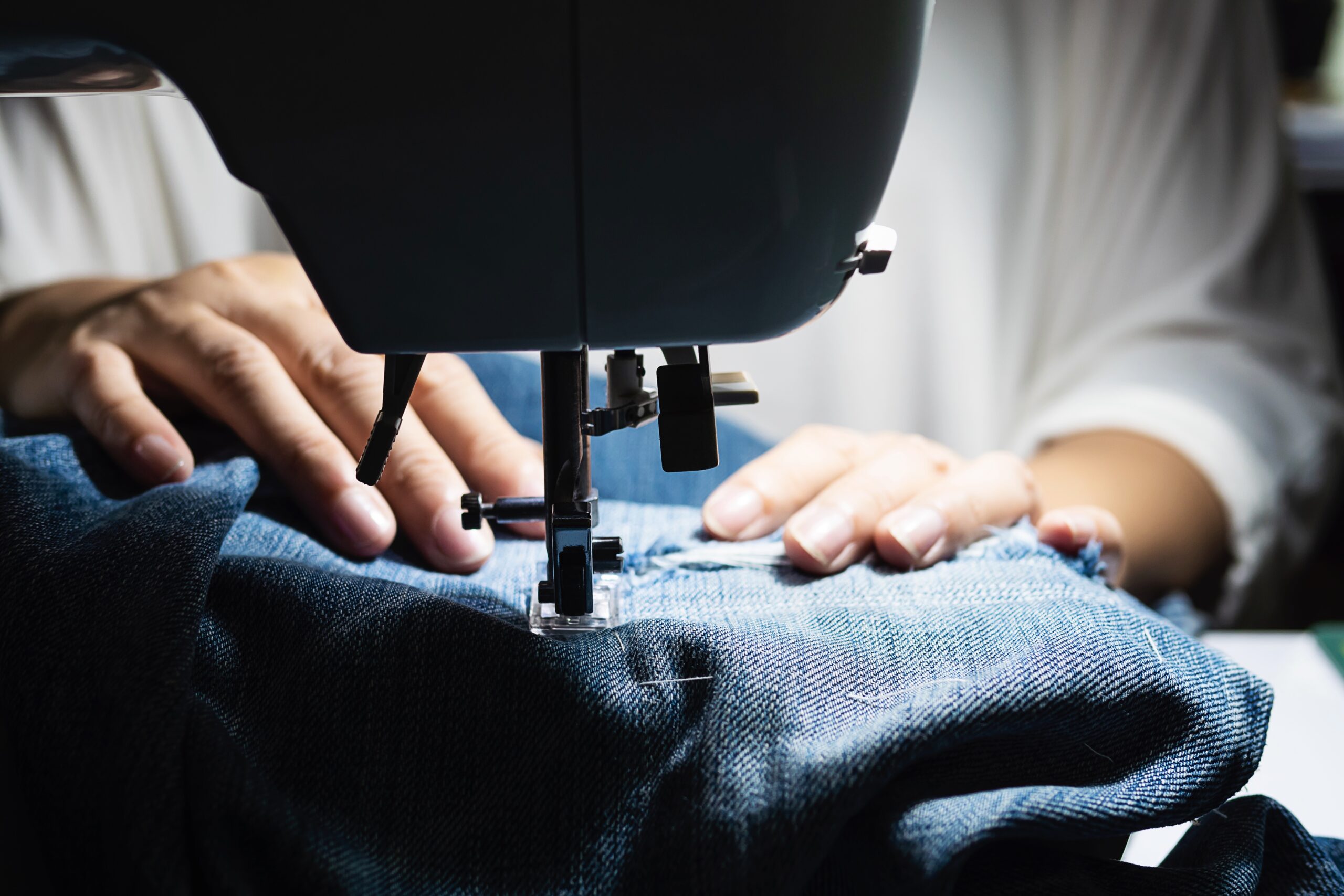 mujer haciendo remiendo jeans usando maquina coser concepto costura bricolaje casero scaled